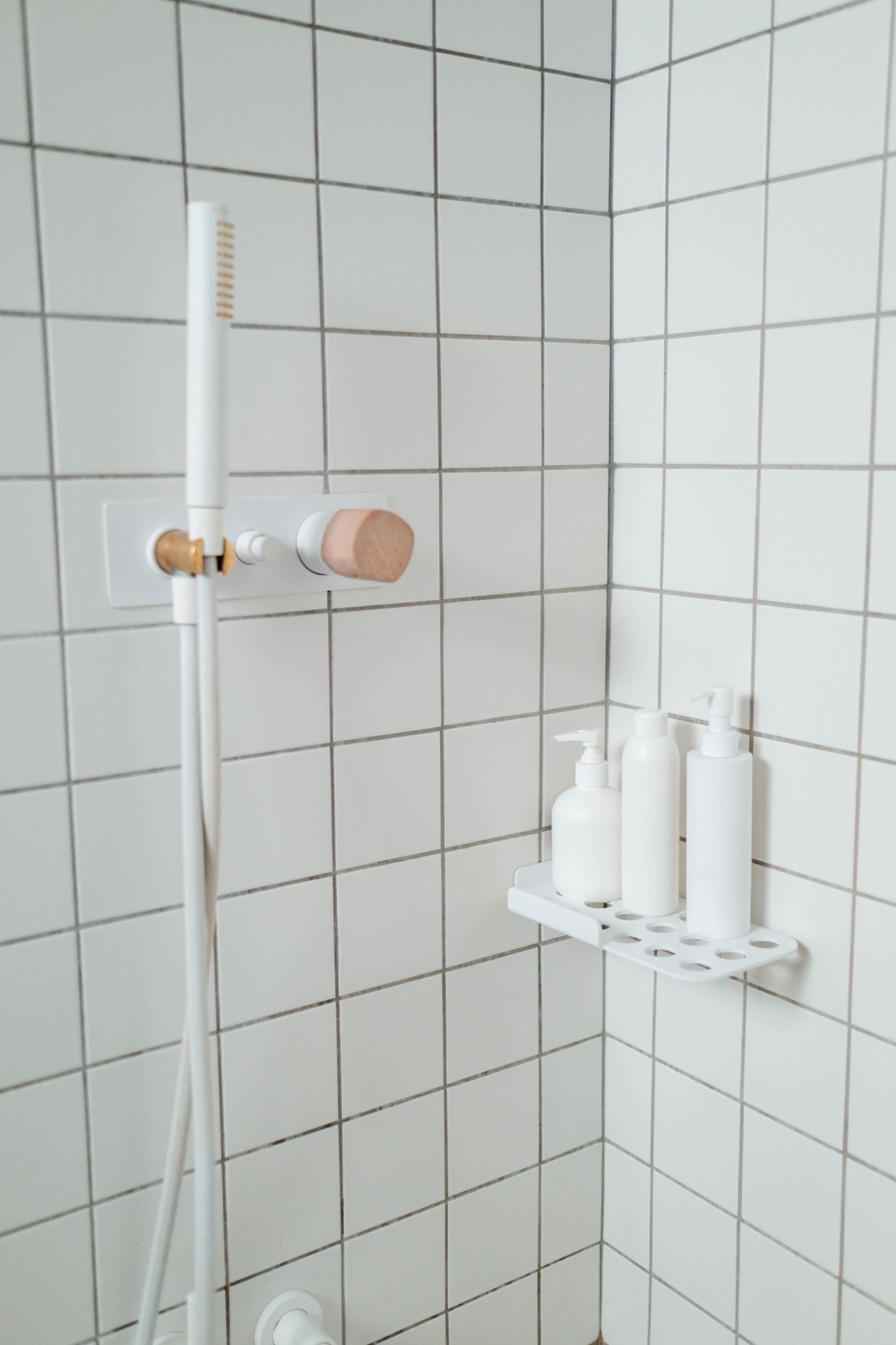 new shower head on white tile shower walls in a guest bathroom remodel Pflugerville TX
