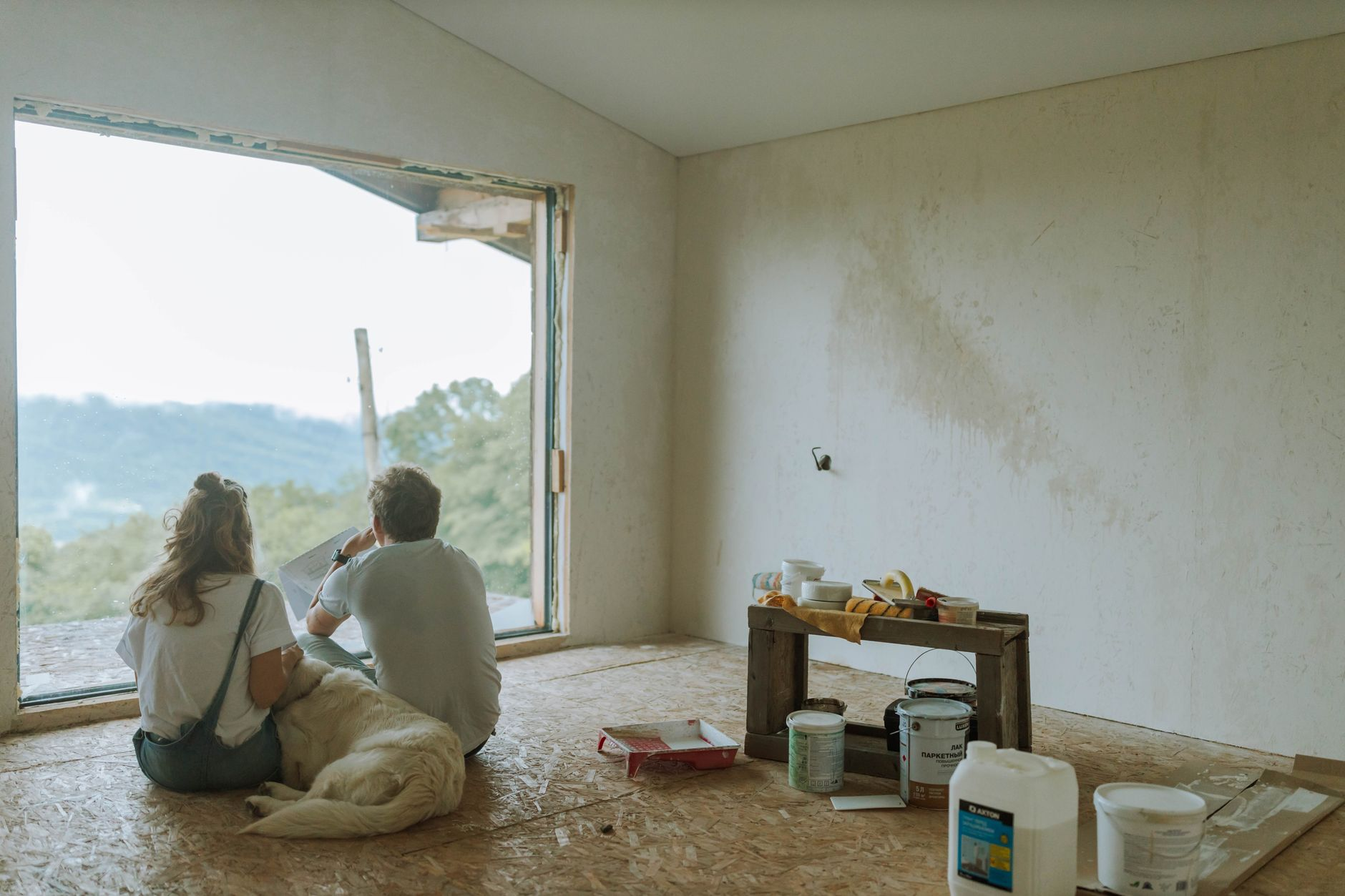 Couple and dog relaxing in a partially renovated room planning small home renovations with BH Remodeling serving Austin a…