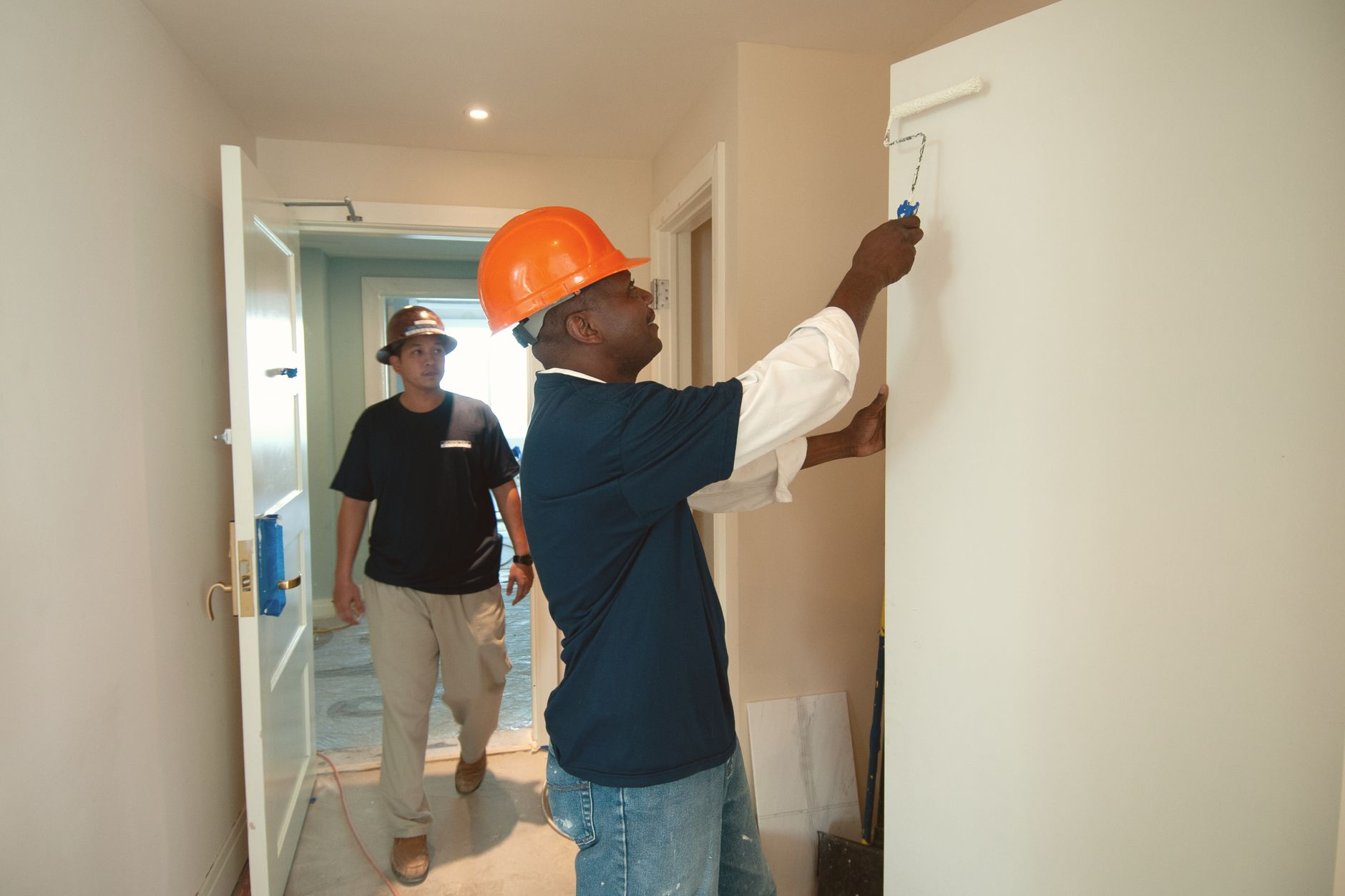 Two professional painters working together on interior painting in an Austin area home remodel