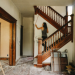 Woman renovating a wooden staircase during a whole home remodeling project in Austin and Round Rock TX