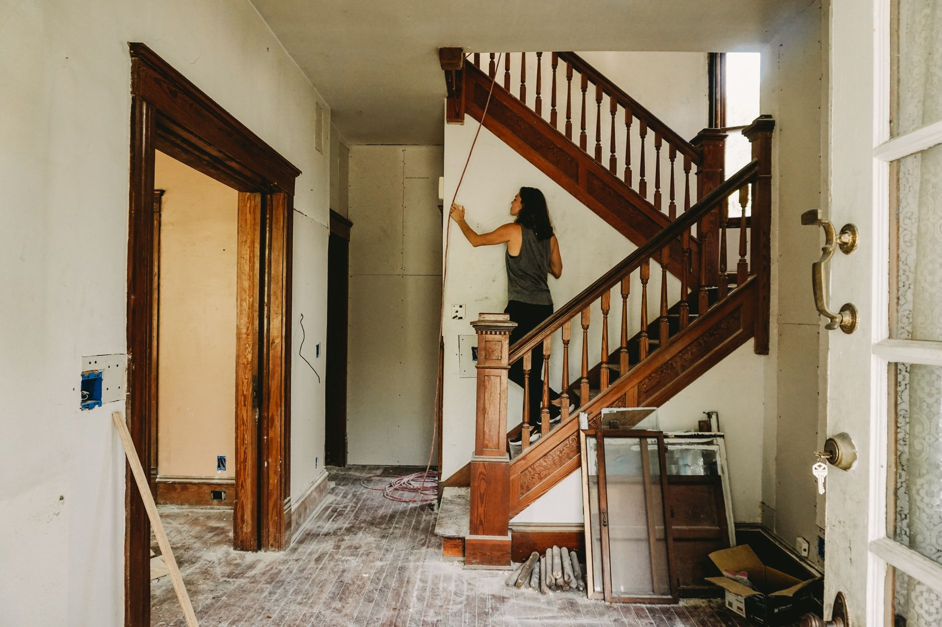Woman renovating a wooden staircase during a whole home remodeling project in Austin and Round Rock TX