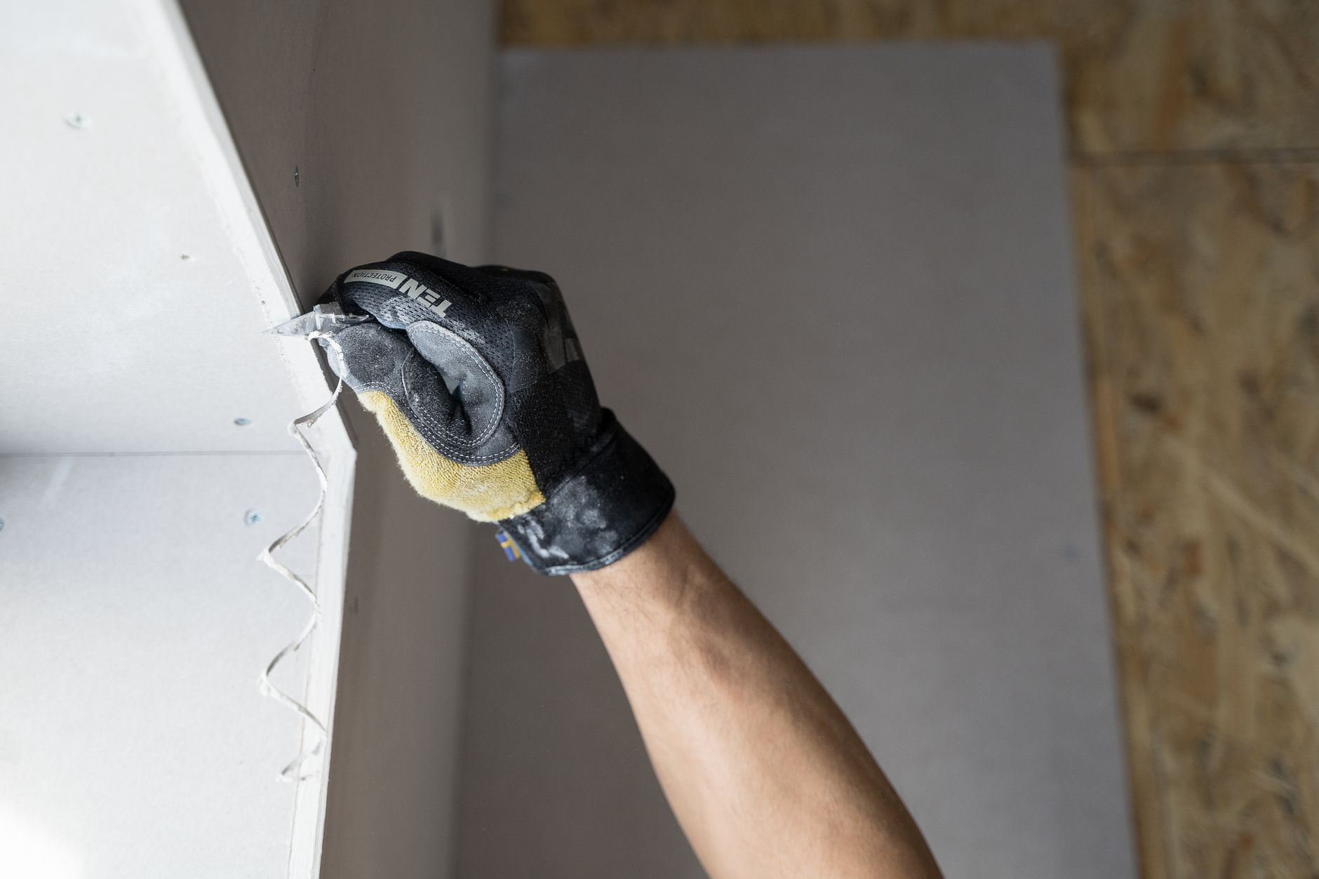 Gloved hand applying plaster for drywall repair, a common approach for Austin and Round Rock homeowners